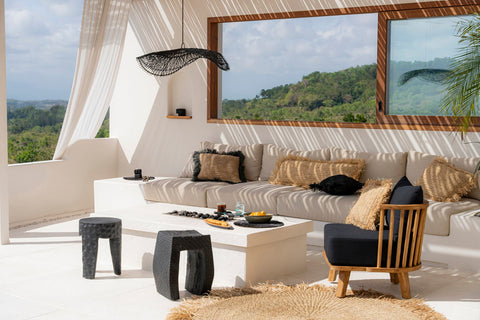 The Chapeau lamp van zwart rotan op zonnig overdekt terras.