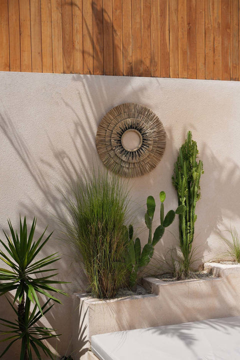 Bazar Bizar Mengdong muurdecoratie aan een buitenmuur met meerdere planten.
