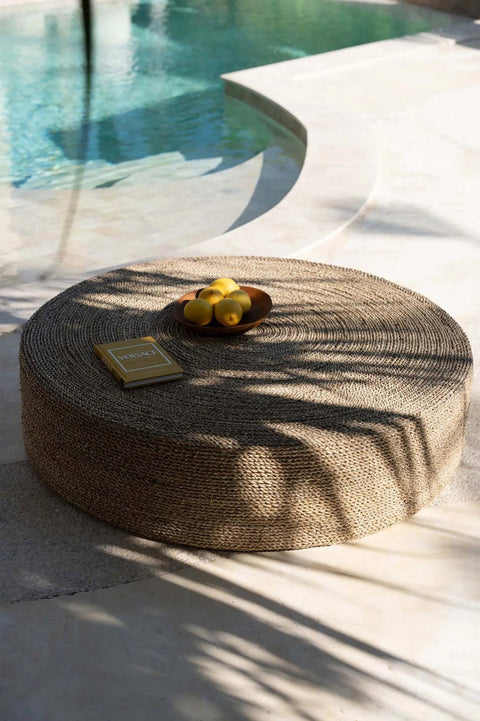 Bord 'Teak Root Organic' op rotan poef bij zwembad – boho setting