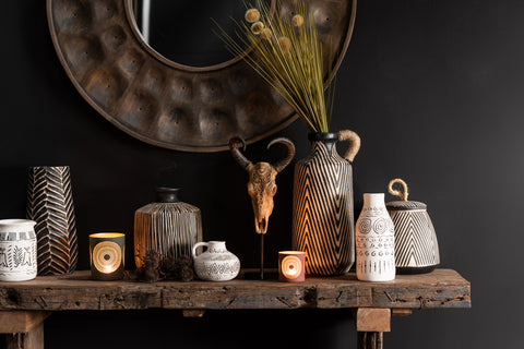 J-Line console Rough in donker interieur, aangekleed met decoratieve accessoires.