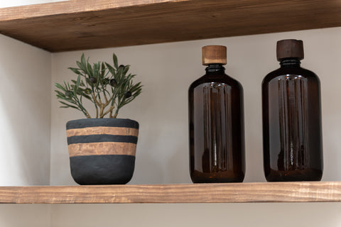 Twee J-Line flessen Vintage Brown op houten plank met plantje ernaast