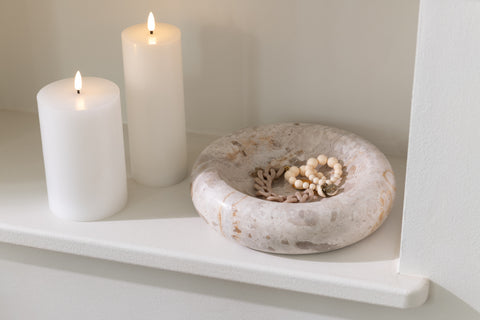 J-Line kom Marble Beige small gevuld met juwelen, naast LED-kaarsen