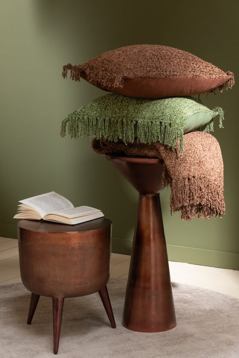Donkerbruin J-Line Kussen ‘Chocolate’ gestyled op een stapel met decoratieve sierkussens in een gezellig interieur