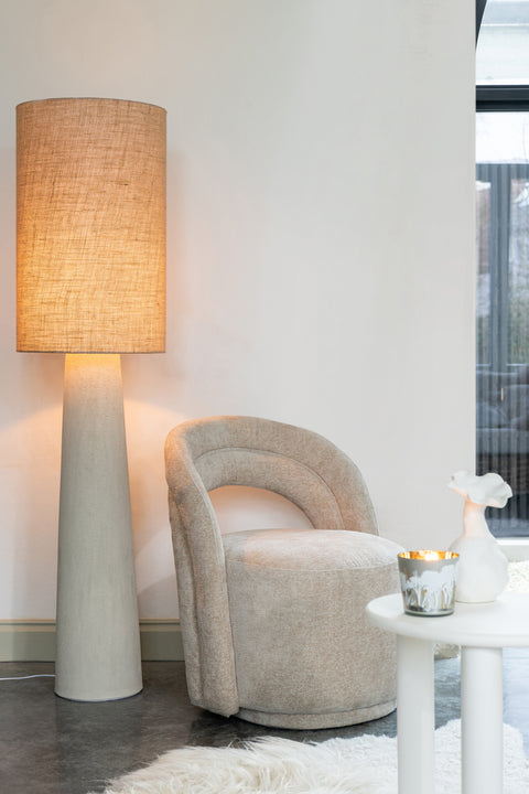 J-Line Lamp Ava Large – witte vloerlamp brandend naast beige stoel en wit bijzettafeltje