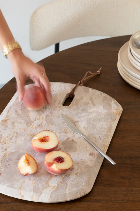J-Line Marble Beige snijplank small met doorgesneden fruit op houten tafel.