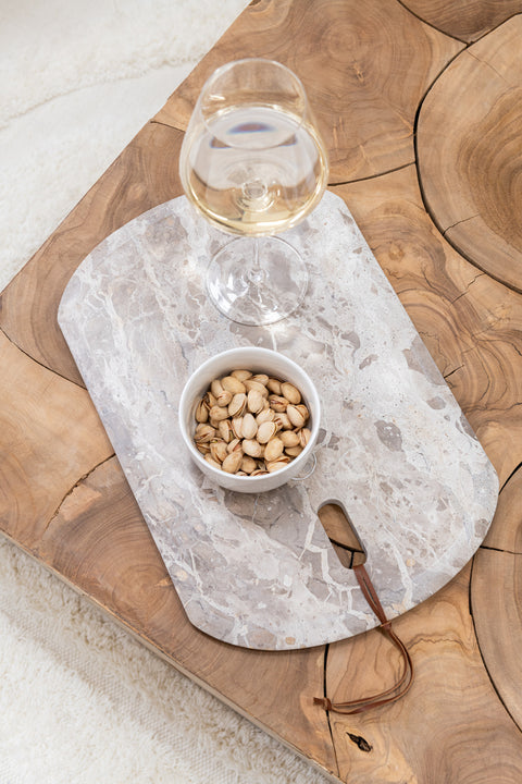 J-Line Marble Beige snijplank small met nootjes en glas wijn op houten tafel.