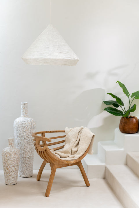 J-Line plaid ‘Muslin’ over houten meubel gedrapeerd – rustgevende texturen in een warm interieur