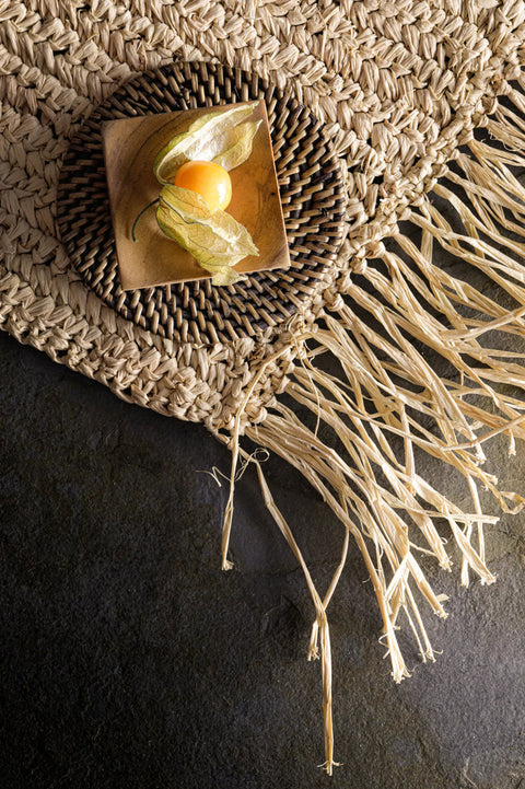 Detailfoto placemat 'The Fringe Raffia Natural' met bord en diner