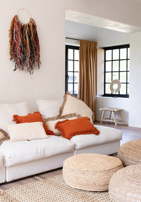 Poef 'Raffia Flores' gebruikt als salontafel in wit interieur