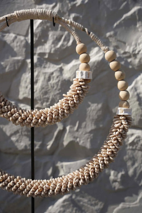 Close-up van schelpenketting ‘Double’ in een bohemian interieur op kast
