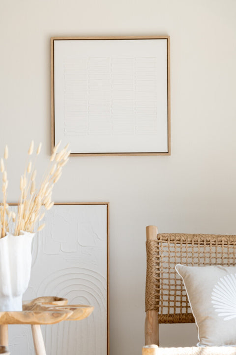 Wit schilderij 'Lines' met houten lijst in een warm beige interieur