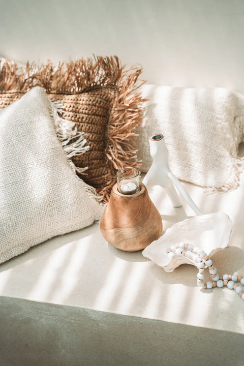 Theelichthouder ‘The Candle Drop’ op lichte linnen bank met zachte kussens en natuurlijke accessoires in bohemian stijl