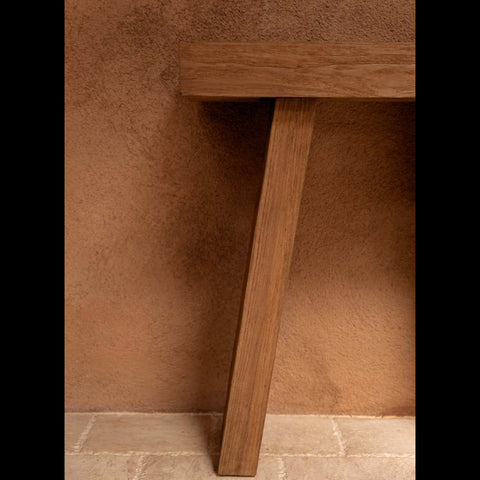 Detail van de The Stance teakhouten console in een warm interieur