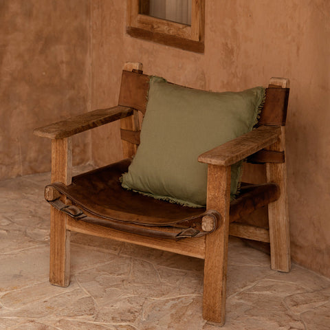 Groen sierkussen The Minty Fresh in bruine stoel in warm interieur