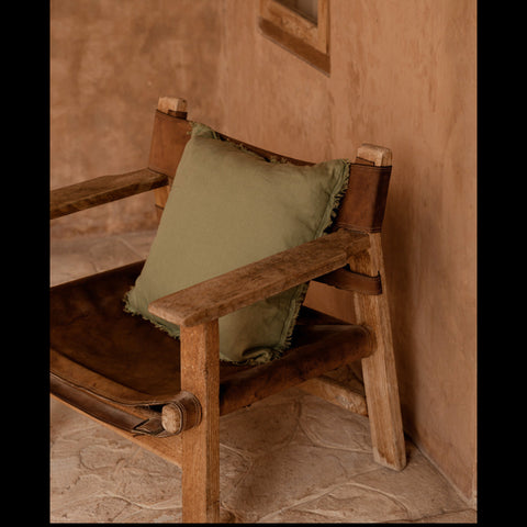 Groen katoenen sierkussen The Minty Fresh in bruine stoel