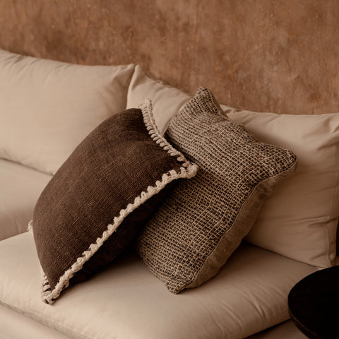 Kussen The Espresso Edge op beige zetel gecombineerd met ander kussen