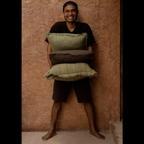 Man met verschillende Bazar Bizar sierkussens waaronder The Minty Fresh