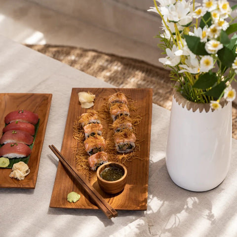 The Teak Root chopsticks op een houten sushischotel