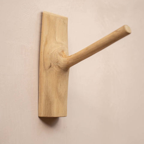 Naturelkleurige houten kapstokhaak aan een beige muur