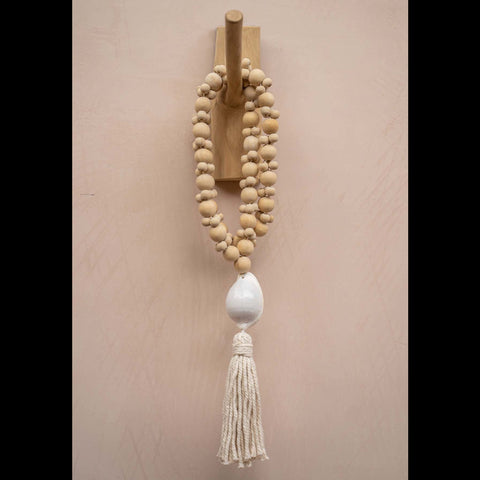 Teakhouten kapstokhaak met een decoratieve kralenketting in naturel tinten