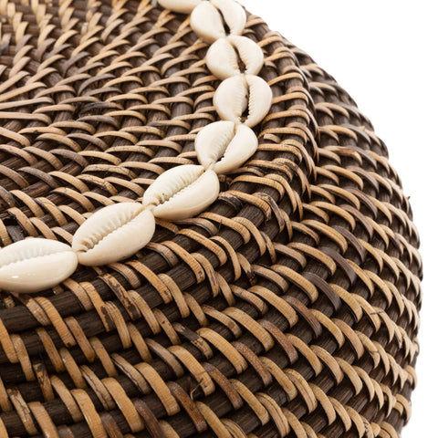 Detail van de kaurischelpen op het deksel van de bruine rotan mand