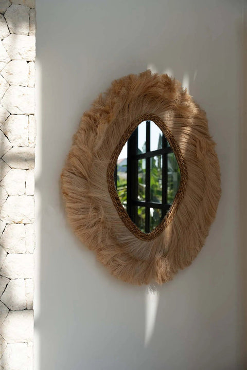 Grote spiegel The La Duchessa tegen een beige muur met zachte schaduwen en natuurlijke sfeer.