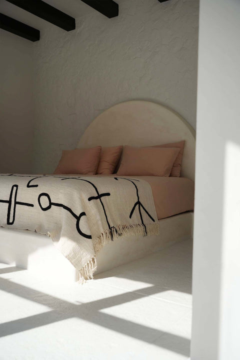 Bazar Bizar The Evil Eye plaid als stijlvolle bedsprei op een opgemaakt bed.