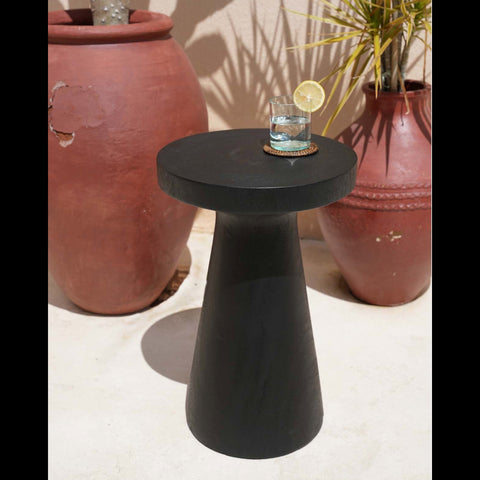 Zwarte The Fiji bijzettafel met glazen blad en terracotta bloempotten op een terras