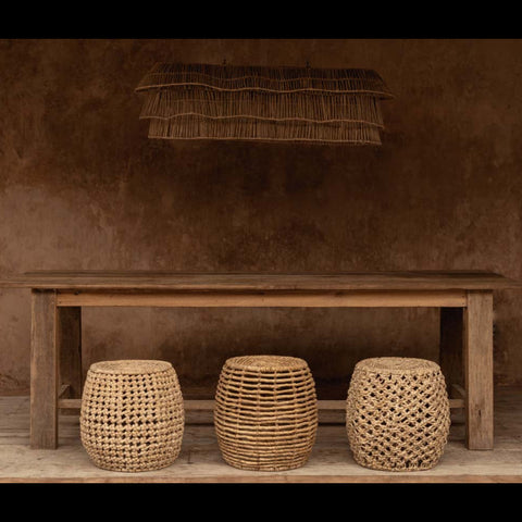 The Gustih krukje gecombineerd met andere natuurlijke krukjes onder een houten tafel