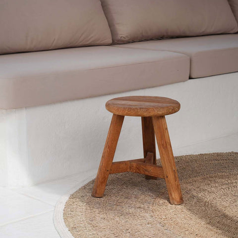 Bazar Bizar The Noguchi krukje op een rotan mat voor een bank met beige kussens