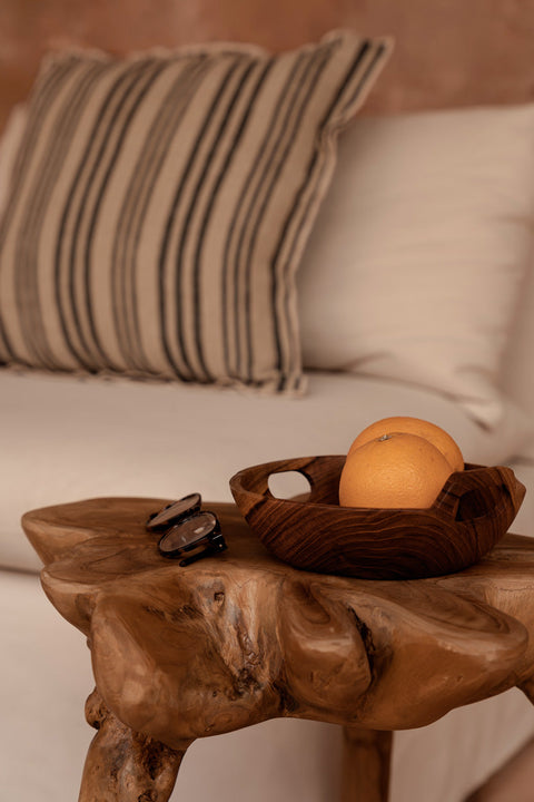 Bazar Bizar The Nordic Stripe kussen op een beige zetel met een bruin houten salontafeltje ervoor.