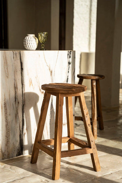 Bazar Bizar The Shibori barstoel voor een marmeren toog in een zonnig interieur