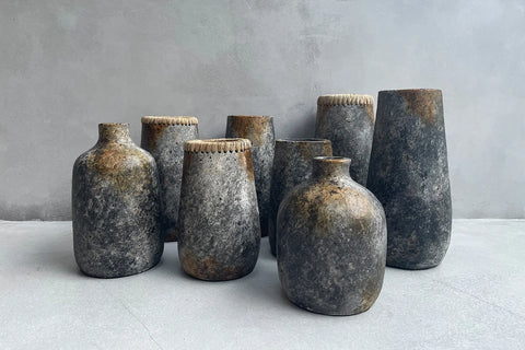 Kleine Sneaky vaas in sfeervolle setting met diverse terracotta vazen