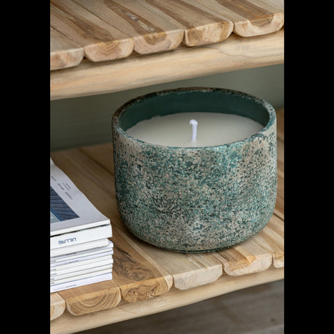 Brandende buitenkaars turquoise cement pot op houten tafel