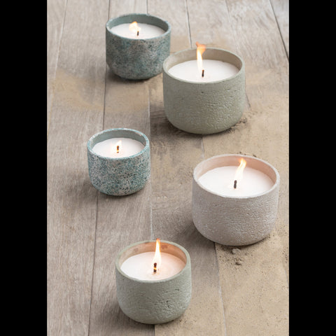Brandende buitenkaarsen turquoise cement pot J-Line op terras met verschillende formaten