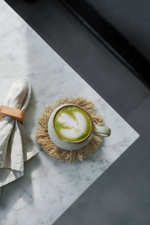Cascais mok met matcha thee op rotan onderlegger in boho interieur