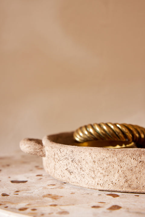 Lichtbeige groot cementen bord van J-Line op terrazzo tafel met gouden ringen als decoratie