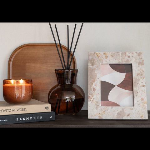 J-Line Fotokader Marble Beige 13x18 gecombineerd met zwarte geurstokjes en een bruine geurkaars.