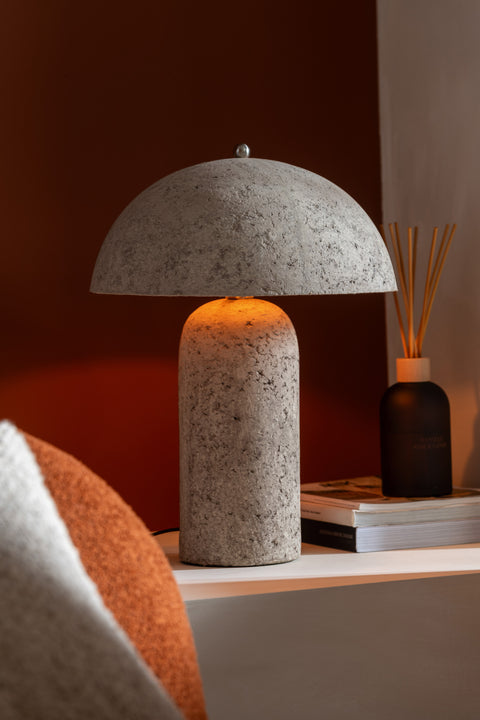 J-Line Mushroom lamp brandend tegen terracotta achtergrond, met boekjes en geurstokjes.