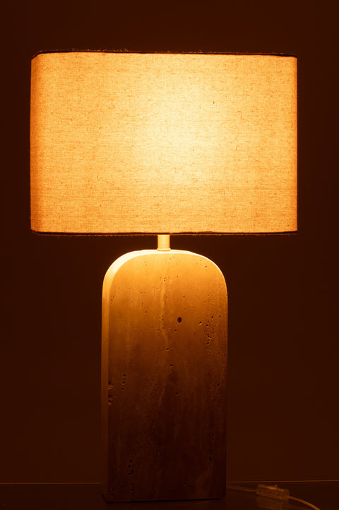 Brandende J-Line Travertin Beige lamp in donker, sfeervol licht.