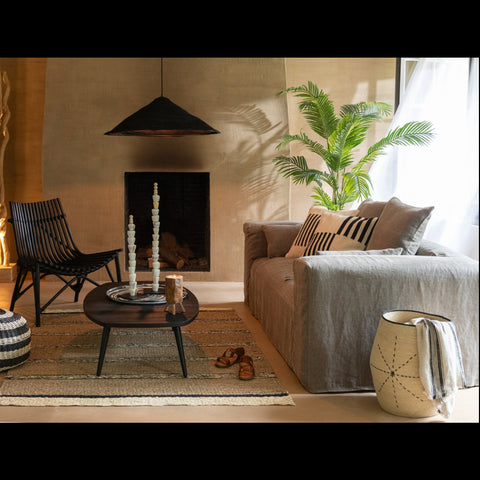 J-Line Monaco zetel met naturel linnen hoes in interieur met zwarte salontafel, rotan hanglamp en stoel.