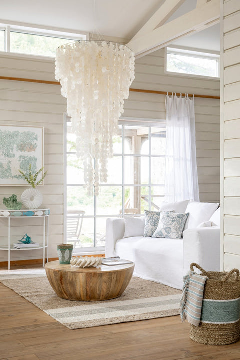 J-Line Monaco zetel met lichte hoes in een wit interieur met grote hanglamp.