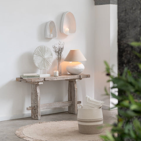 Set van drie witte wandrekken boven een houten console in een warm en natuurlijk interieur.