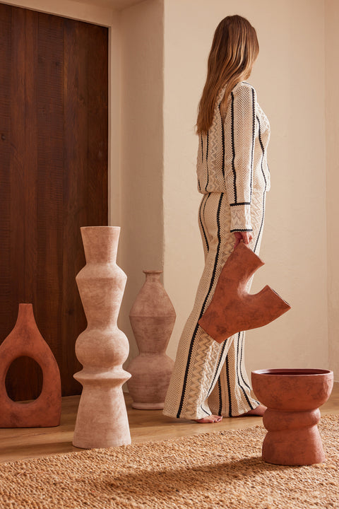 Grote keramieken vaas Ubi van J-Line in bruine tint, geplaatst in de achtergrond van een warm interieur