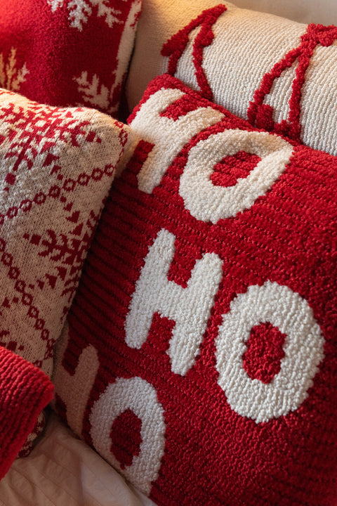 J-Line kerstkussens HO HO HO in rood en wit gecombineerd met andere kerstdecoratie op een bank