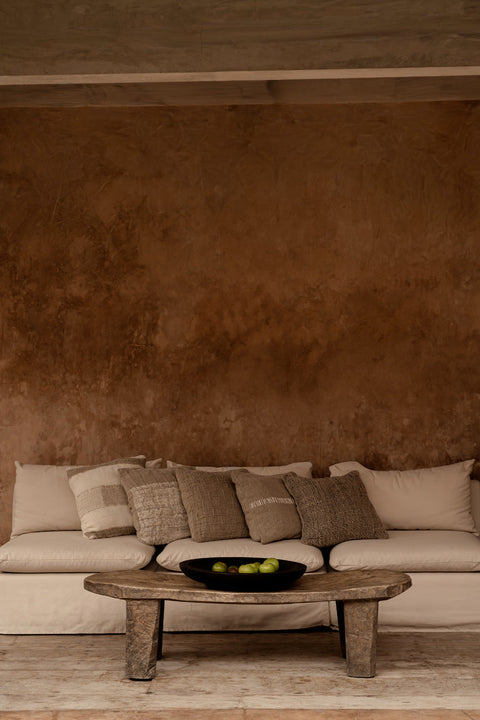 Linnen kussen The Linen Edit op beige zetel met houten salontafel