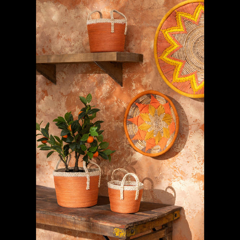 Bohemian muurdecoratie van bananenbladeren tegen oranje muur