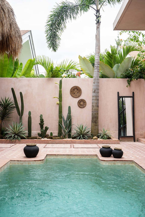 The Jasmine Plate rotan muurdecoratie in een sfeervolle setting bij een zwembad