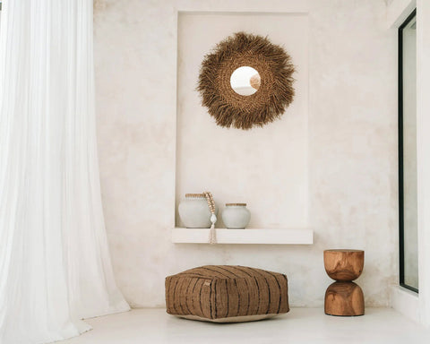 The Early Monday Mirror in een warm beige interieur met vloerkussen en houten krukje