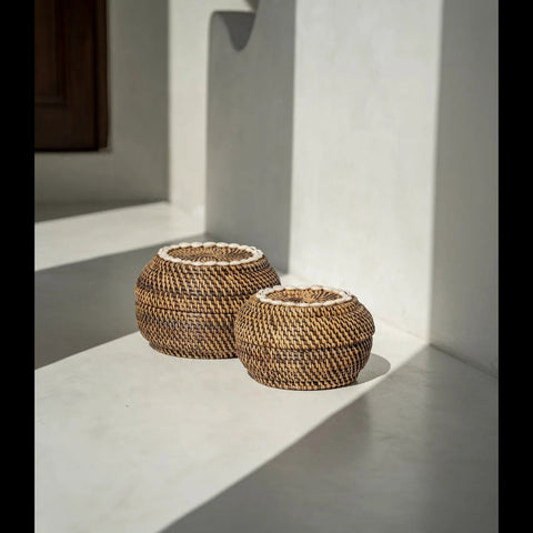 The Colonial Peek-a-Boo rotan mand naast dezelfde mand in een ander formaat op de vloer